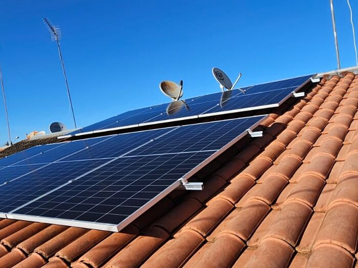 Painéis solares em telhado sob céu azul